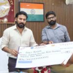 District Magistrate Distributes Checks Under Pradhan Mantri Fasal Bima Yojana; Farmers' Faces Light Up