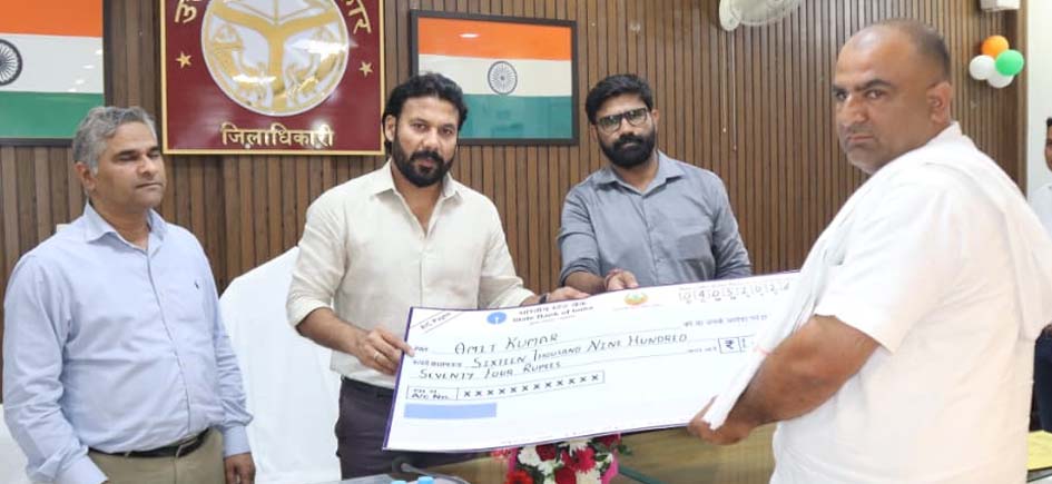 District Magistrate Distributes Checks Under Pradhan Mantri Fasal Bima Yojana; Farmers' Faces Light Up